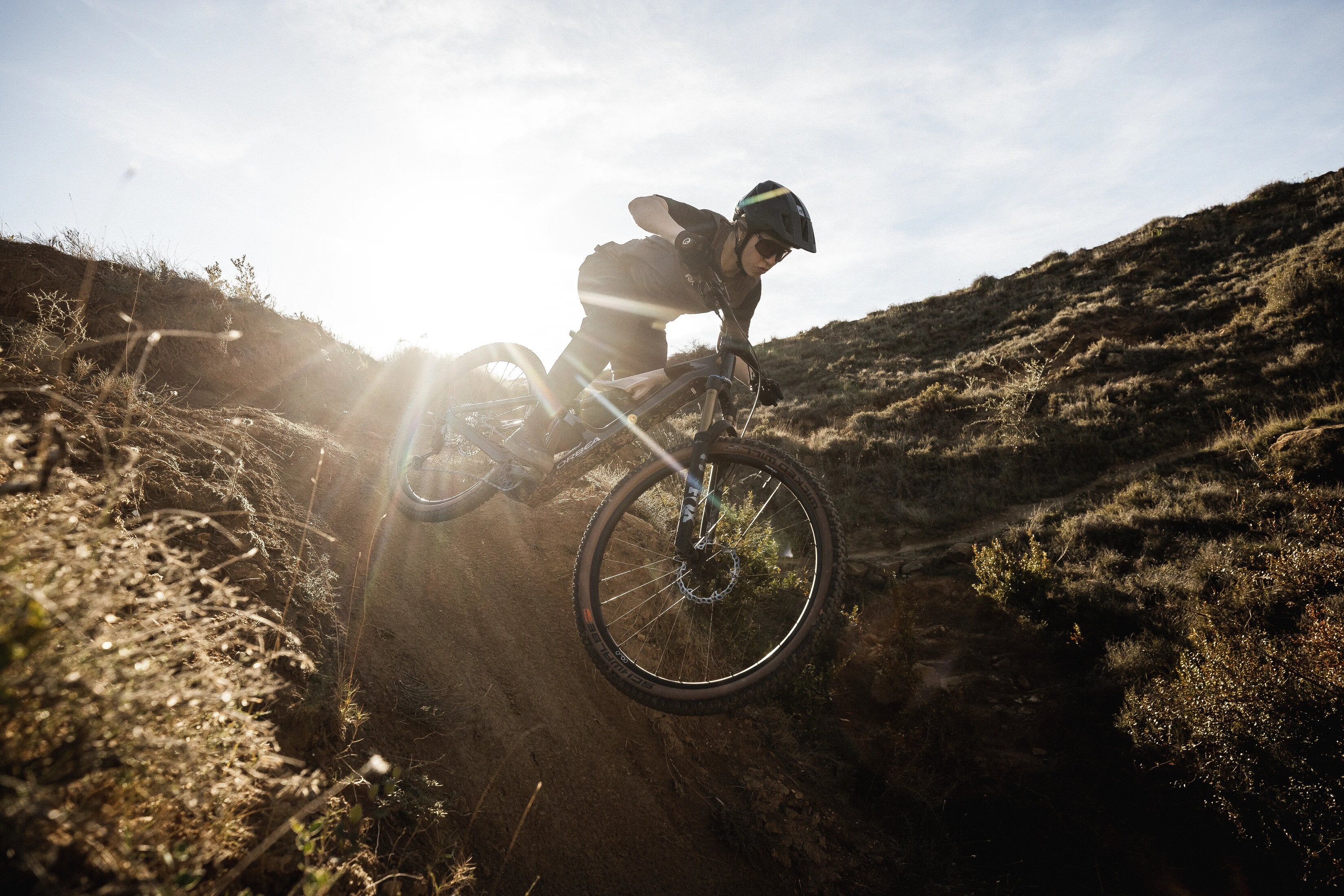 Kona hjólar niður brekku á Orbea Rise SL rafmagnsfjallahjóli